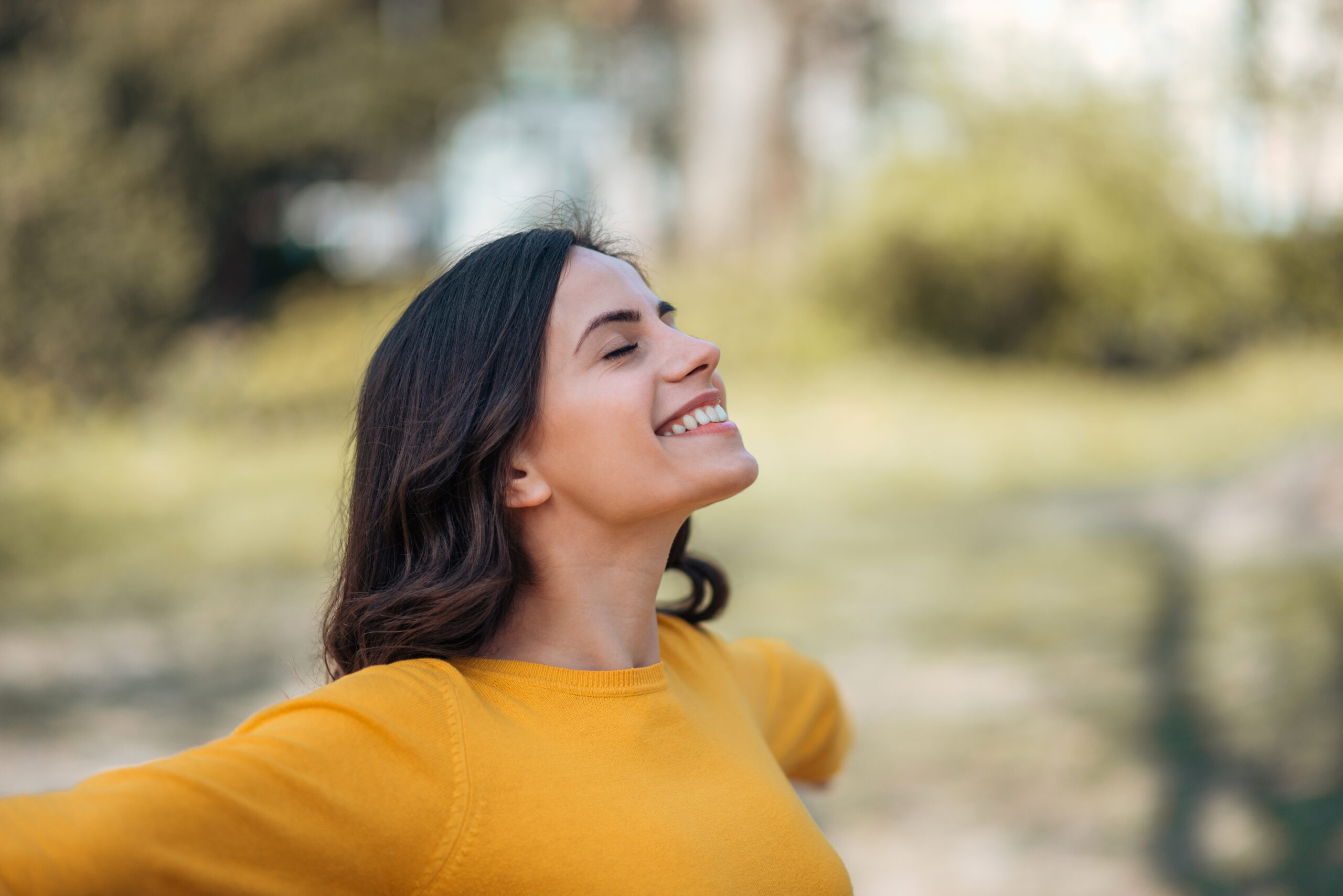 Close-up image of a young woman relaxing in the park in the springtime.